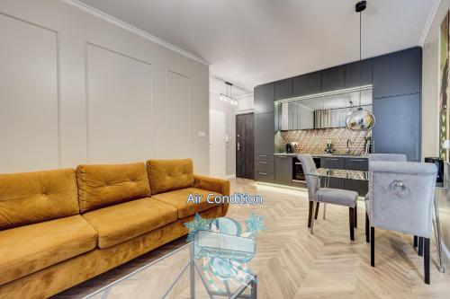 Allure NOVA Aparthotel في شتتين: غرفة معيشة مع أريكة وغرفة طعام