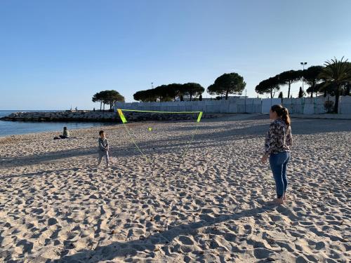 a woman and a child flying a kite on the beach at Amour Azur Appartement pour 2 avec jacuzzi et terrasse à 2 minutes de la mer in Vallauris