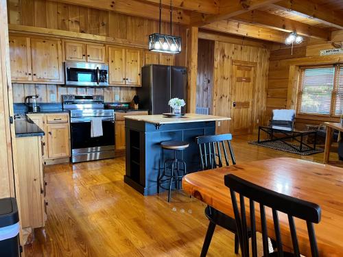 a kitchen with a table and a stove and refrigerator at Splashtacular: Indoor Pool~Gorgeous Views~HotTub~GameRoom~Resort in Gatlinburg