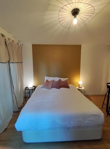 une chambre avec un grand lit blanc avec un plafond dans l'établissement Studio Vannes - centre-ville et parking, à Vannes