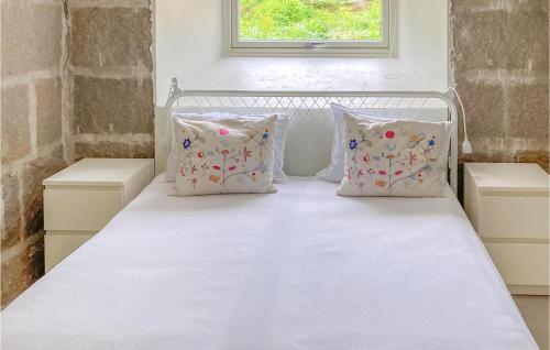 a white bed with four pillows and a window at Nice Home In Vestery With Wifi in Rød