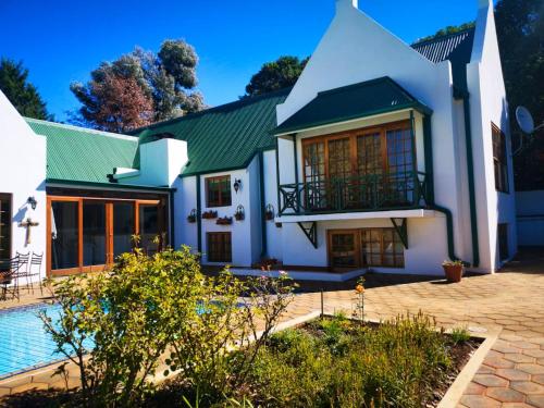 a large white house with a swimming pool at The Gables-Clarens in Clarens