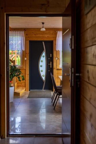 a door to a house with a surfboard on it at SZUMI LAS in Białowieża