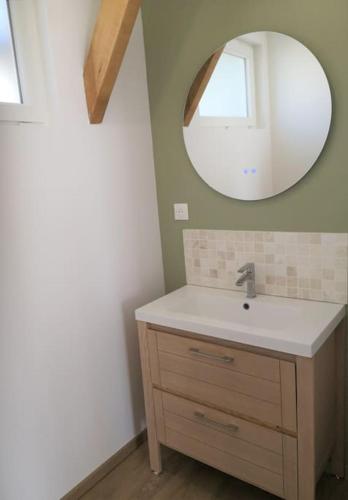 une salle de bain avec un lavabo et un miroir dans l'établissement T2 proche Marais avec vue cathédrale et garage à moto, à Bourges