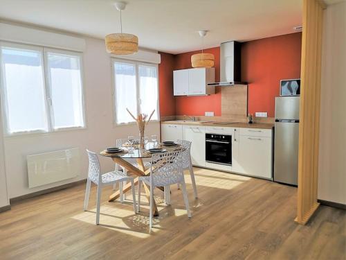 une cuisine avec une table et des chaises dans une pièce dans l'établissement T2 proche Marais avec vue cathédrale et garage à moto, à Bourges