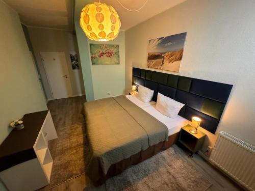 a small bedroom with a bed and a chandelier at F-F Haus Monteuren Unterkunft in Neuhausen auf den Fildern
