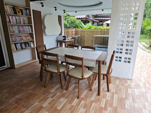 a table and chairs in a room with a book shelf at HOMETHAI RESORT (โฮมไทยรีสอร์ท) in Ban San Pu Loei