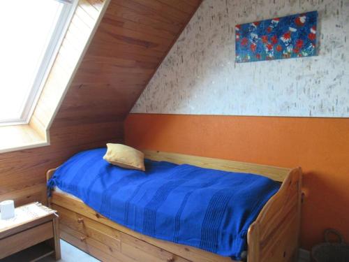 - une chambre avec un lit en bois et une couette bleue dans l'établissement Kérandro, à Porspoder