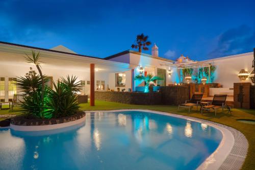 a swimming pool in front of a house at night at Finca del Moral in Tinajo
