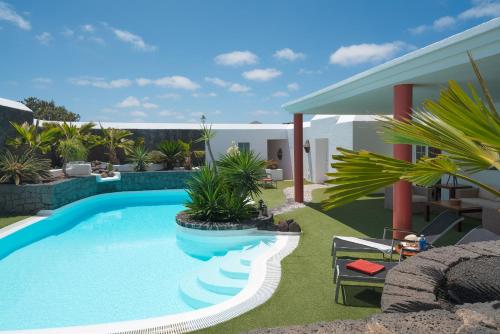 a swimming pool in the yard of a house at Finca del Moral in Tinajo