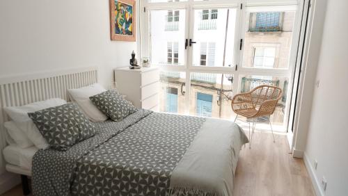 a bedroom with a bed and a large window at casa Chloe in Ourense