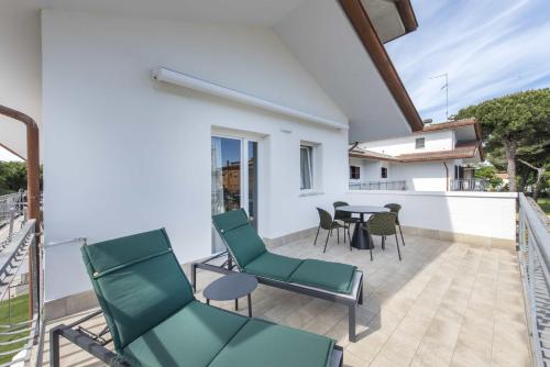 a patio with chairs and a table on a balcony at Guesthouse Stadio in Lignano Sabbiadoro