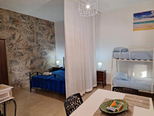 a room with a dining table and two bunk beds at Villa Carrieri in Marina di Lizzano