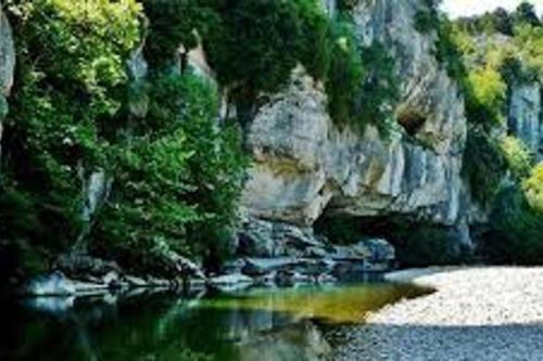 a painting of a river with rocks and trees at Studio idéal pour vos vacances in Saint Alban Auriolles