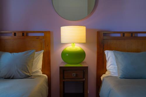 a bedroom with two beds and a lamp on a night stand at Finca del Moral in Tinajo