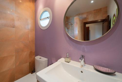 a bathroom with a white sink and a mirror at Finca del Moral in Tinajo