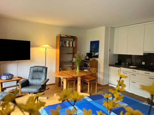 a living room with a table and a kitchen at Obm See in Davos Wolfgang