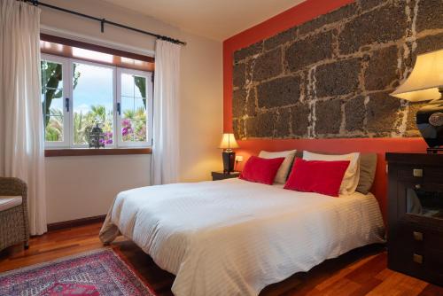 a bedroom with a large bed with red pillows at Finca del Moral in Tinajo