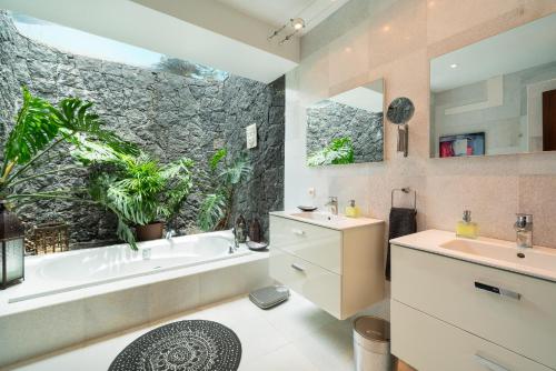 ein Badezimmer mit einer Badewanne, einem Waschbecken, einer Badewanne und einer Badewanne in der Unterkunft Finca del Moral in Tinajo