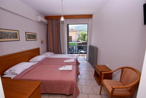 a hotel room with two beds and a window at Aristotelis Hotel in Stavros