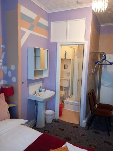 a bedroom with a bed and a sink and a bathroom at My Adam Hotel in Blackpool