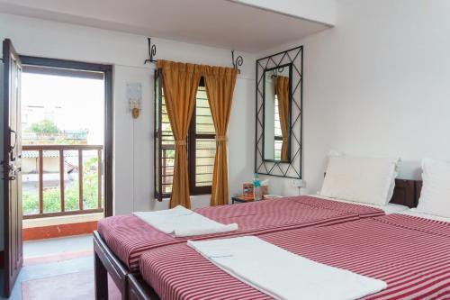 two beds in a room with a window at Kailash Guest House in Puducherry