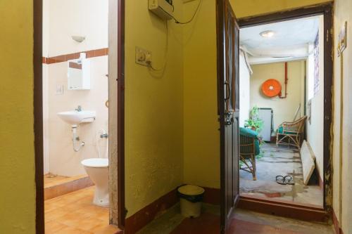 a bathroom with a toilet and a sink in a room at Kailash Guest House in Puducherry