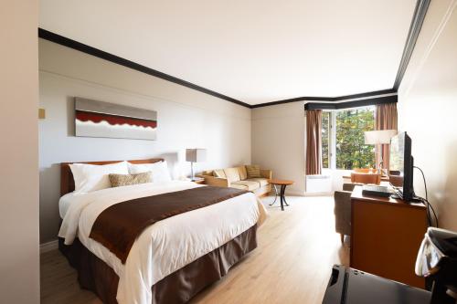 Habitación de hotel con cama grande y ventana en Auberge de la Montagne Coupée, en Saint-Jean-de-Matha