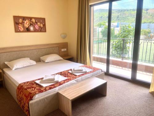 a hotel room with a bed and a large window at Maria Garden in Kranevo
