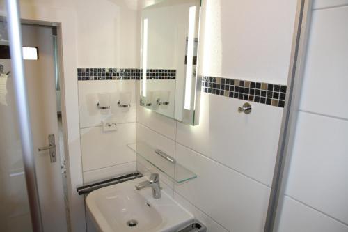 a white bathroom with a sink and a mirror at Wohnung Julius 8 in Sankt Andreasberg