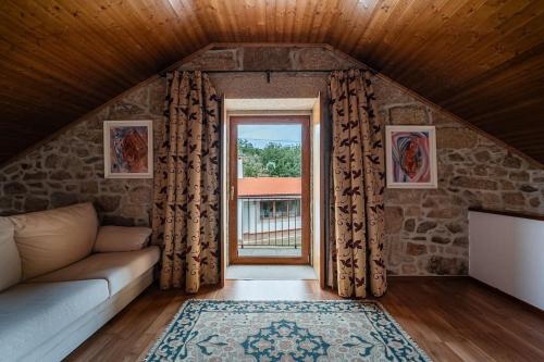 a living room with a couch and a window at Casa do Alambique - Douro in Armamar