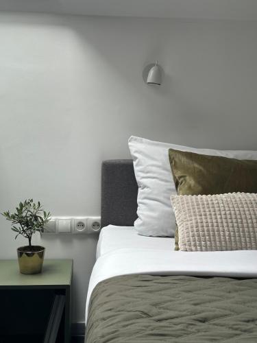 a bedroom with a bed with a plant on a table at Moment in Strzelce Opolskie