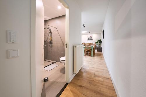 a hallway with a toilet and a dining room at The Suite Eindhoven by T&S in Eindhoven