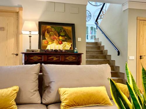 a couch in a living room with a painting on the wall at El Patio de los Jazmines Boutique-House in Consuegra