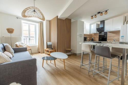 un salon et une cuisine avec un canapé et une table dans l'établissement Cosy Saint-Pierre centre-ville, à Clermont-Ferrand