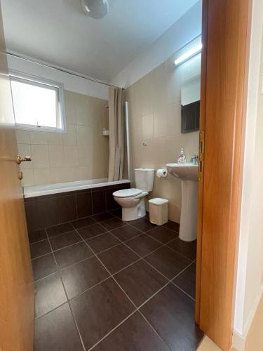 a bathroom with a toilet and a tub and a sink at Fig Tree View Apartments in Protaras