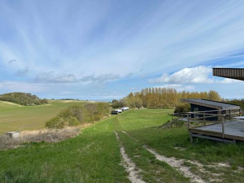 a dirt road in the grass next to a building at Cozy Tiny House In Nature - Holiday Home C in Sejerby