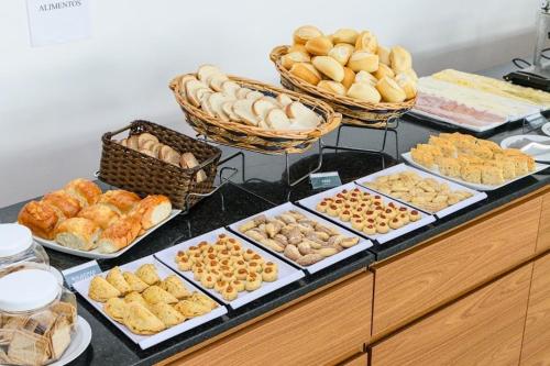 a buffet filled with different types of bread and pastries at Recife Infinity Pool - VIP in Recife