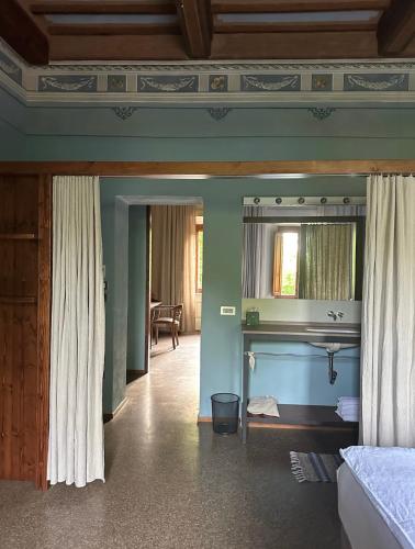 a room with a bed and a mirror in a room at B&B lo scudaio Palazzo Marchionneschi in Montescudaio