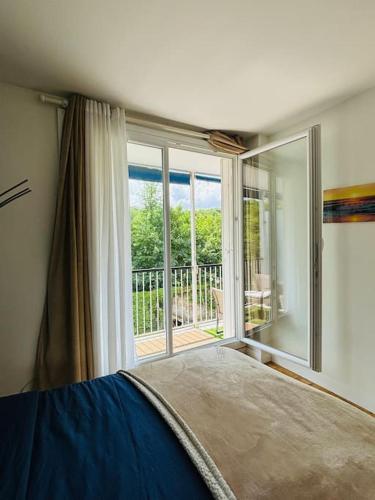 une chambre avec un lit et une grande fenêtre dans l'établissement Proche Château de Versailles avec balcon vu sur une forêt et parking gratuit pour 5 personnes maximum, à Versailles
