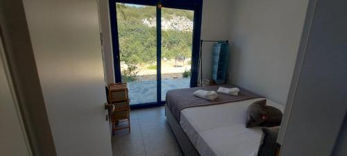 a man bending over a bed in a room with a window at Villa Edna Crete in Agios Nikolaos