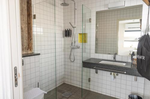 a bathroom with a shower with a sink and a mirror at Salt & Sill in Klädesholmen