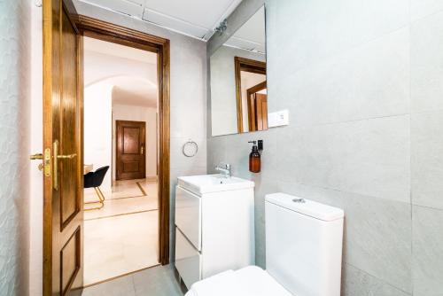 une salle de bain avec toilettes, lavabo et miroir dans l'établissement Wekey Homes Granada, El encanto de Navas Centro, à Grenade