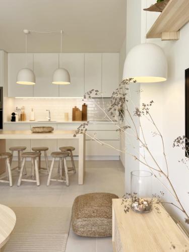 a kitchen with white cabinets and a wooden table at Forte House T2 by Portugal Hideaway in Tavira