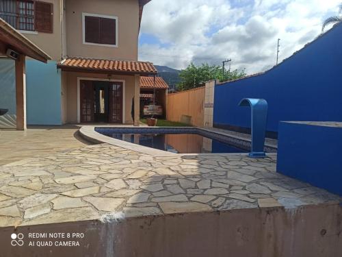 un patio trasero con piscina y una casa en Pousada Litoral Norte Caragua en Caraguatatuba