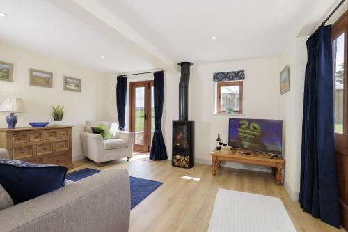 a living room with a couch and a fireplace at The Stables in Mickleton