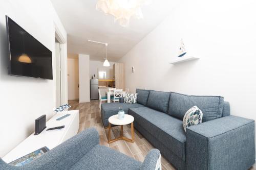 a living room with a blue couch and a table at La barca apartments in Becici