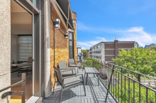 een balkon met stoelen en tafels op een gebouw bij Eat, Explore & Enjoy Downtown Montreal at this Sleek City Escape located in Plateau Mont-Royal - Apt 4 in Montreal
