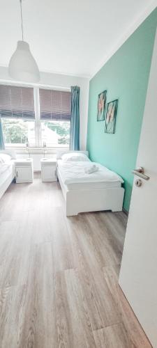 1 dormitorio con 2 camas y pared azul en Zweibettzimmer "Grün" in zentraler Lage en Bremen