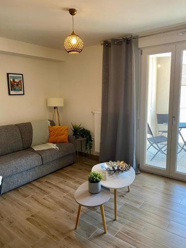 un salon avec un canapé et une table dans l'établissement Ettore Bugatti Appartement -WIFI- Au calme prox Gare, centre-ville et commerces, à Molsheim